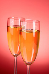 Glass with champagne on red
