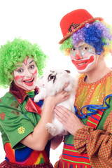 Two joyful clown with a white rabbit