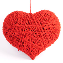 Red heart shape symbol made from wool isolated on white backgrou