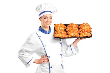 A female baker holding croissants