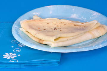 assiette et crèpes sur fond bleu - chandeleur