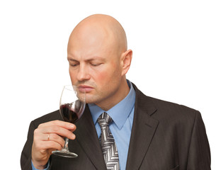 bald man in a suit tastes wine. isolated on white