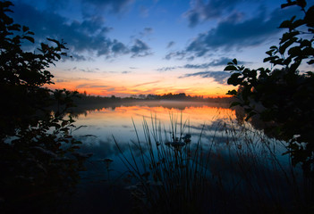 Fototapeta na wymiar After sunset on the foggy lake