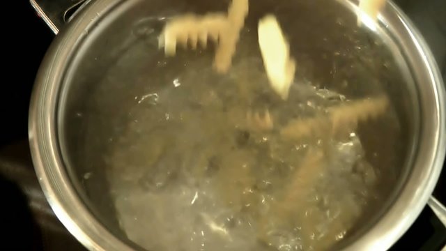 Nudeln fallen in kochendes Wasser