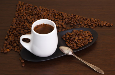 Coffee grains with a white cup and a small spoon