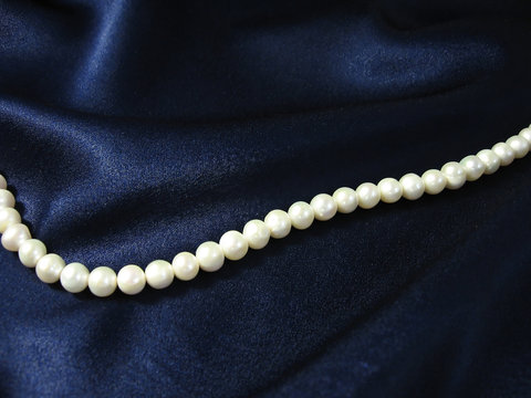 pearls on background the dark blue silk