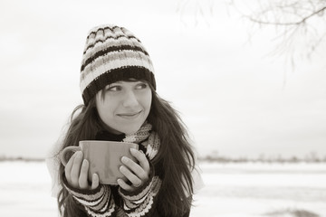 The girl smiles and holding a cup