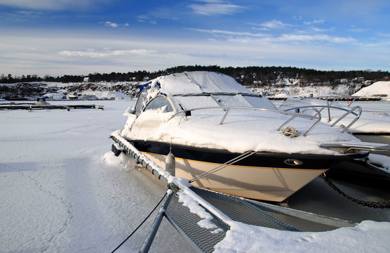 Frozen motorboat in winter harbor