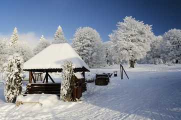 Winter landscape with little wooden house
