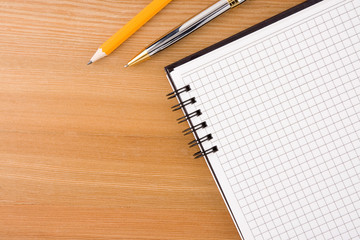 notebook and pens on wood