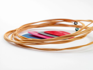 Acoustic guitar strings and plectrums on white background