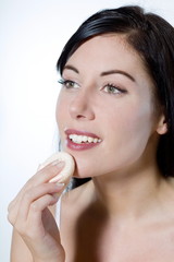 beautiful young woman applying face powder make-up