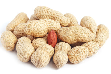 Red peanut kernel in bunch of whole shells on white