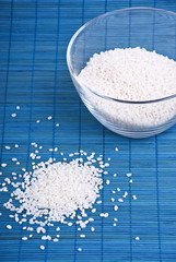 White rice in a glass dish on blue background
