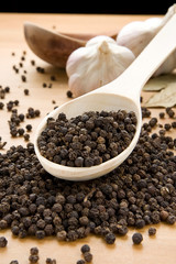 garlic and pepper on wooden spoon