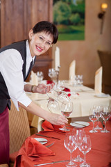 kellnerin deckt den tisch im restaurant