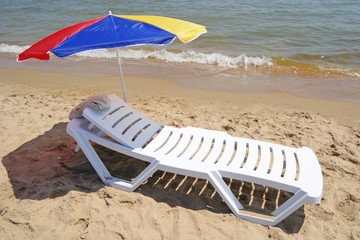 Chaise lounge with an umbrella on a beach