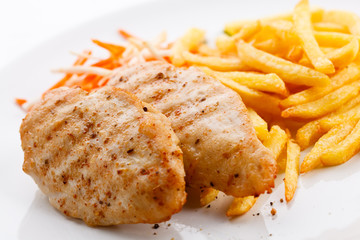 Grilled meat, French fries and vegetables