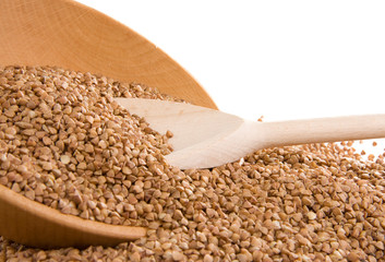 buckwheat and wooden spoon on white