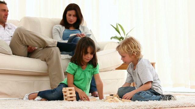 Concentrated brother and sister playing with dominoes
