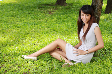 portrait of young woman sitting outdoor on grass