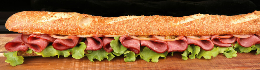 very long baguette with sausage and tomatoes