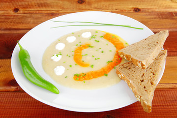Fototapeta na wymiar soup served with bread and pepper on white dish