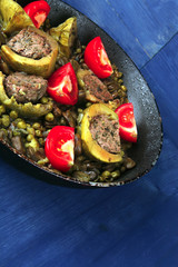 zucchini filled meat cooked with peas and tomatoes