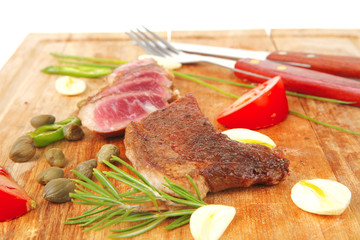 roasted lamb meat fillet ready on wooden board with cutlery
