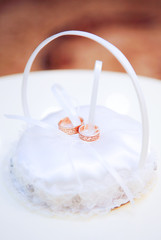 Cushion for the rings and two gold wedding rings with a meander