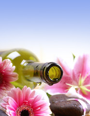 A spa composition of slowers, stones and an oil bottle