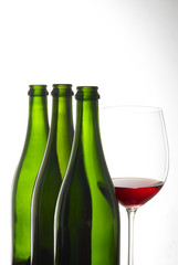 bicchiere di vino rosso  con bottiglie
