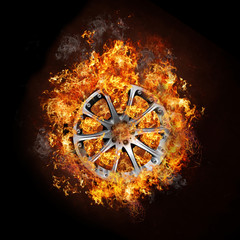 Photo of a car wheel on buring fire with black background