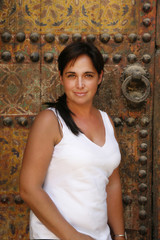 preciosa mujer adulta delante de una puerta dorada