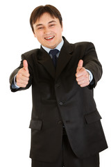 Naklejka premium Smiling young businessman showing thumbs up gesture