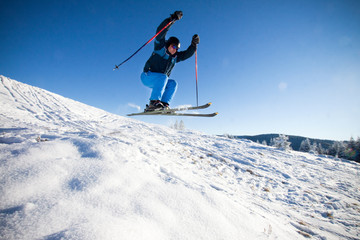 Naklejka na ściany i meble Man practicing extreme ski on sunny day