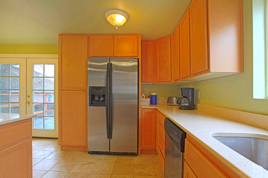 Green and orange kitchen with black refrigerator