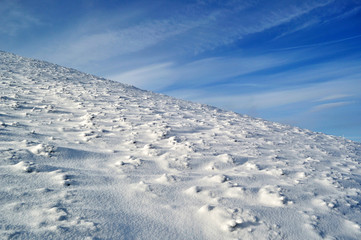snowy mountain slope and blue sky