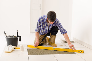 Home tile improvement - handyman with level