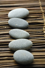 Fototapeta na wymiar Row of gray pebbles on mat