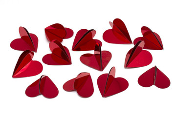 Red foil heart shaped confetti on white background