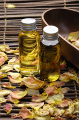 Two bottle of essential oil with dry rose petals