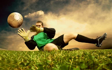Gordijnen Sprong van voetbaldoelman op het buitenveld © Andrii IURLOV