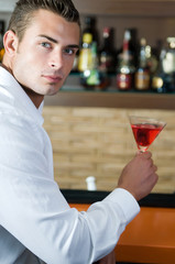 man in a pub with red martini