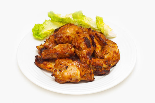 bbq chicken wings on a plate with salad