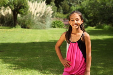 Fototapeta premium Cheerful young school girl posing in park