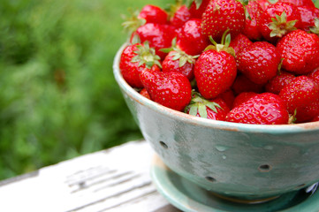 Fresh strawberries in a pottery colander