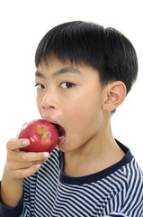Little boy bites off big ripe apple, is isolated