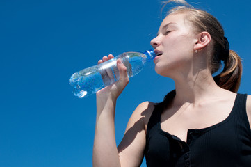 Yyoung woman drinking water after exercise