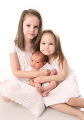 Two girls with newborn sister